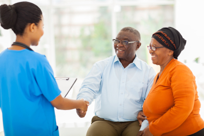 senior couple smiling at the nurse